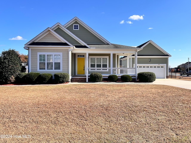 view of front of property with a front lawn, a porch, and a garage