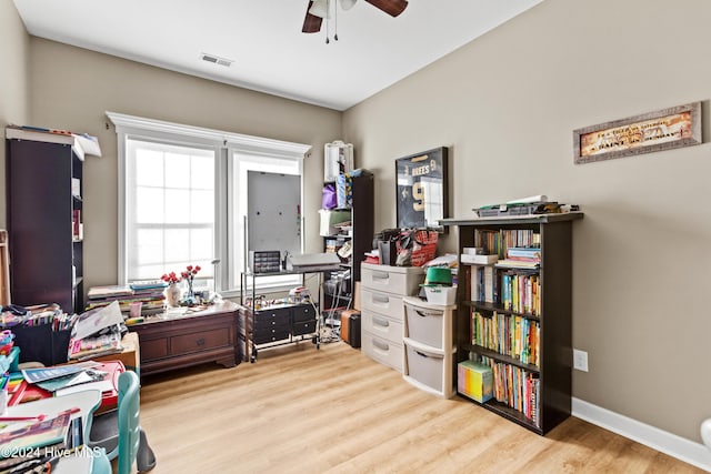 home office with light hardwood / wood-style floors and ceiling fan