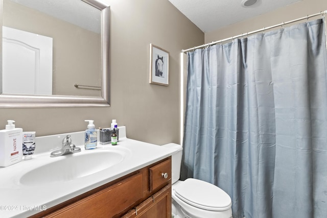 bathroom with vanity, toilet, and a textured ceiling