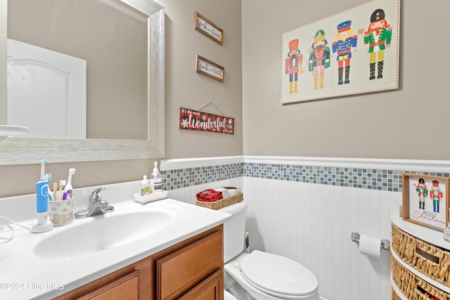 bathroom featuring vanity, tile walls, and toilet