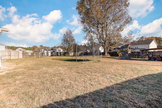 view of yard with a playground and a trampoline