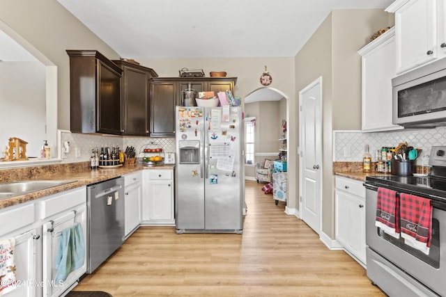 kitchen featuring white cabinetry, tasteful backsplash, light hardwood / wood-style floors, dark brown cabinetry, and stainless steel appliances