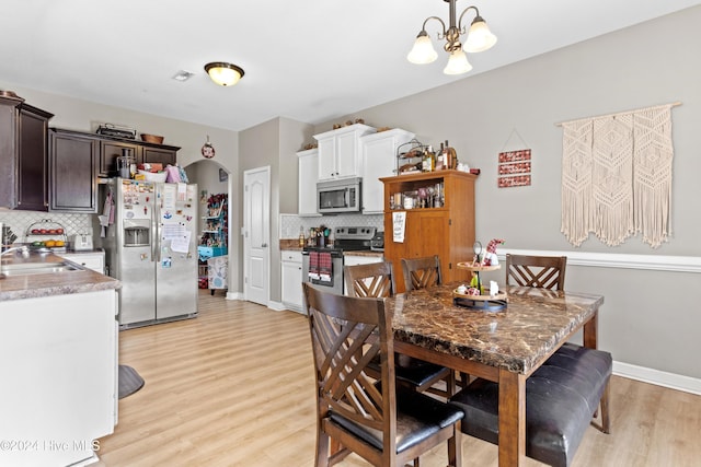 dining room featuring light hardwood / wood-style floors, an inviting chandelier, and sink