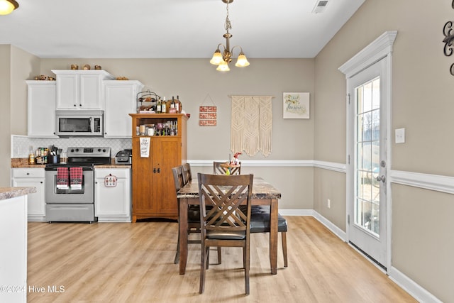 dining room featuring light hardwood / wood-style floors and a notable chandelier