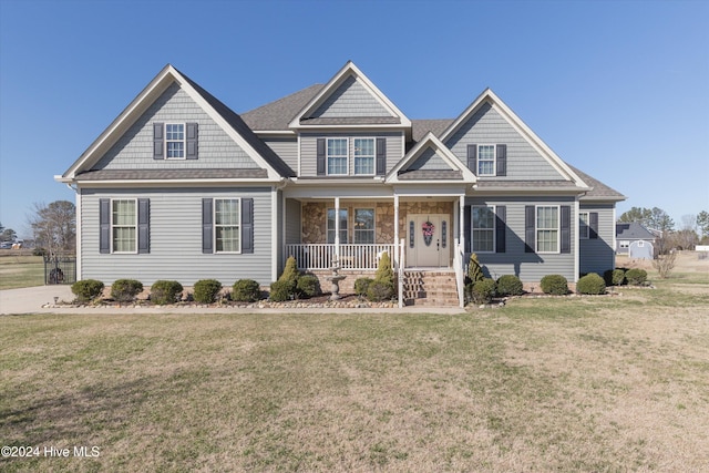 craftsman house featuring covered porch and a front lawn