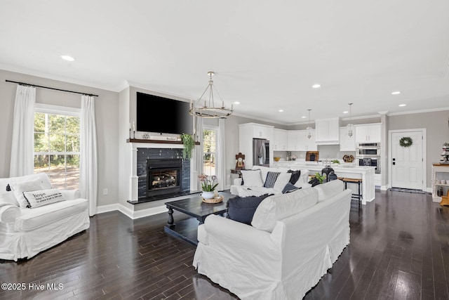 living room featuring dark wood-type flooring, crown molding, and a notable chandelier