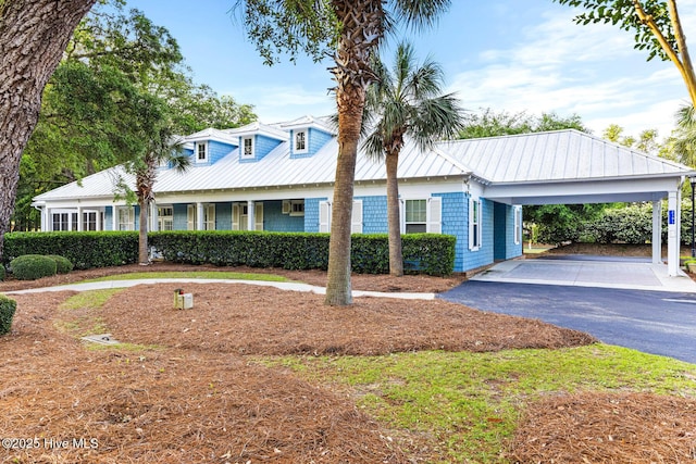 cape cod home with a carport, metal roof, and aphalt driveway