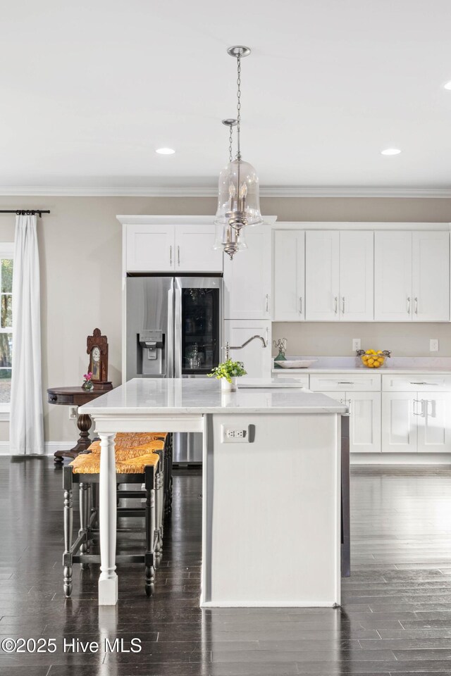 kitchen featuring ornamental molding, a kitchen island, light countertops, white cabinetry, and stainless steel fridge with ice dispenser