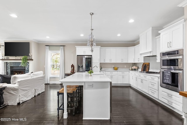 kitchen with dark wood-style flooring, a sink, light countertops, stainless steel appliances, and open floor plan