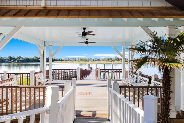 deck with a water view, a gazebo, and ceiling fan