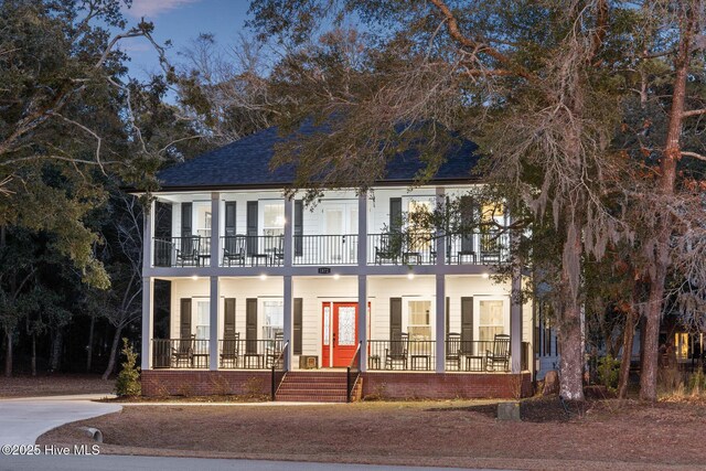 colonial-style house with a balcony and covered porch
