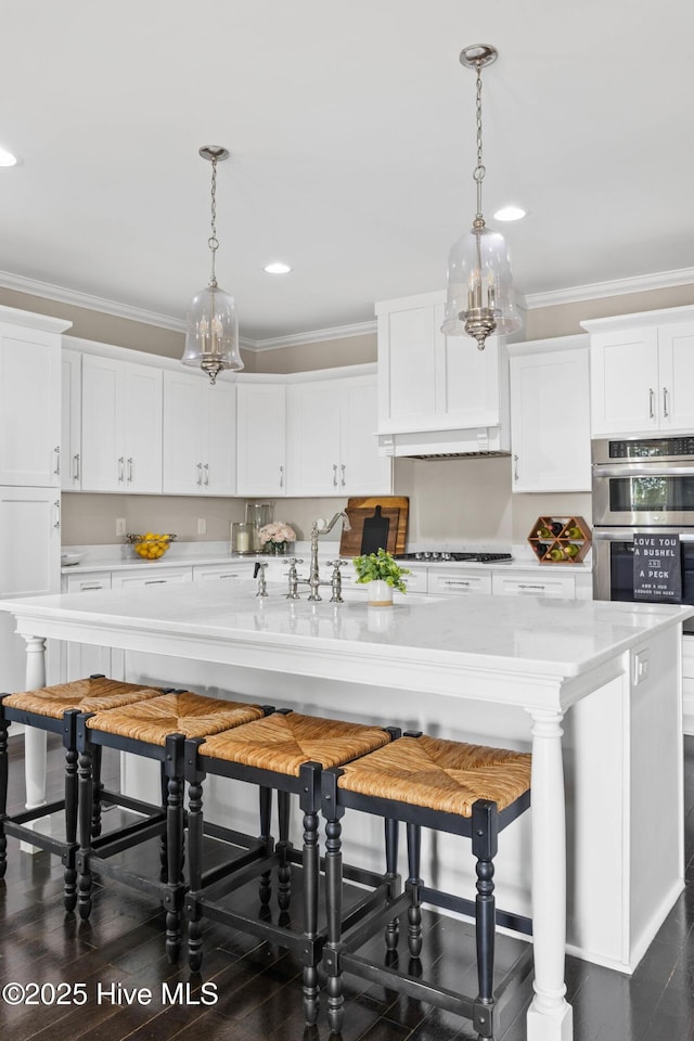 kitchen with white cabinets, a kitchen bar, and a notable chandelier