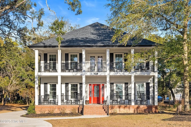 view of front facade with covered porch, french doors, and a balcony