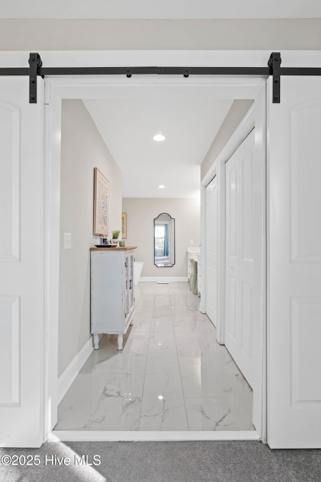 hallway with recessed lighting, baseboards, a barn door, and marble finish floor