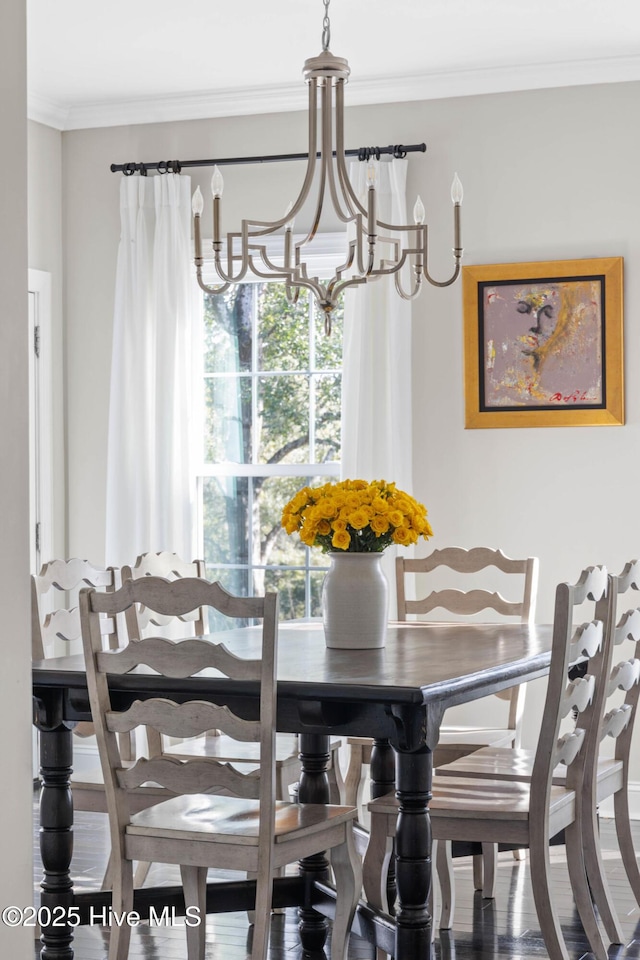 dining area featuring hardwood / wood-style flooring, crown molding, and a chandelier