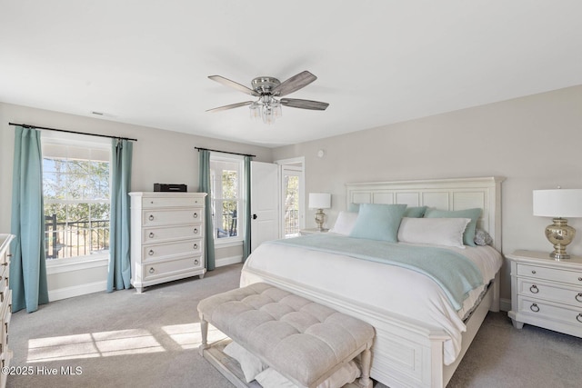 bedroom featuring visible vents, baseboards, ceiling fan, and light carpet