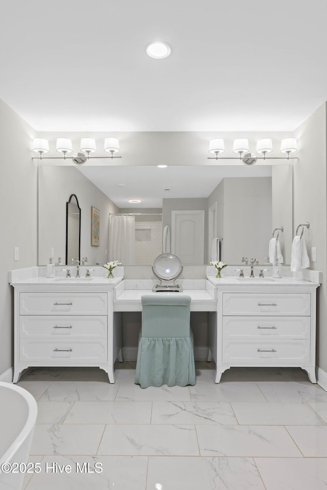 full bathroom featuring a freestanding tub, two vanities, recessed lighting, and marble finish floor