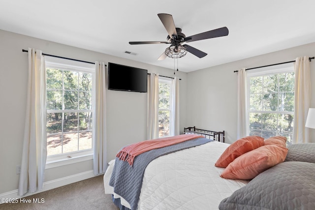 carpeted bedroom featuring visible vents, a ceiling fan, and baseboards