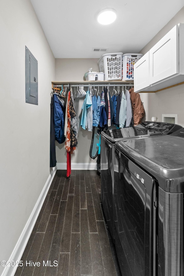 laundry room with cabinet space, washer and dryer, dark wood finished floors, baseboards, and electric panel