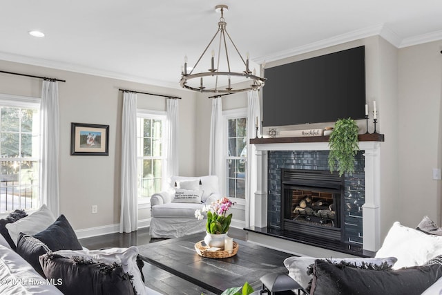 living area with an inviting chandelier, ornamental molding, baseboards, a fireplace with raised hearth, and dark wood finished floors