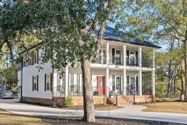 view of front facade with a balcony and covered porch