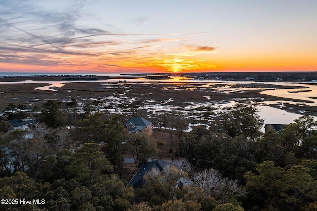 aerial view at dusk featuring a water view