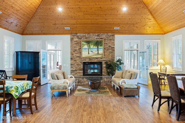 living area with wooden ceiling, a fireplace, high vaulted ceiling, and visible vents