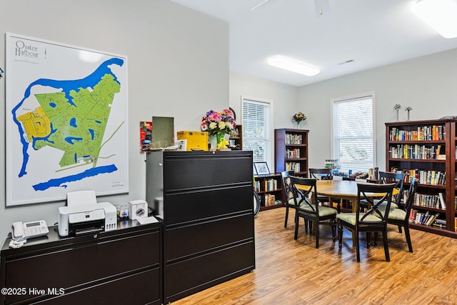 dining space featuring light wood-style flooring and visible vents