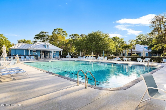 community pool with a patio area and fence
