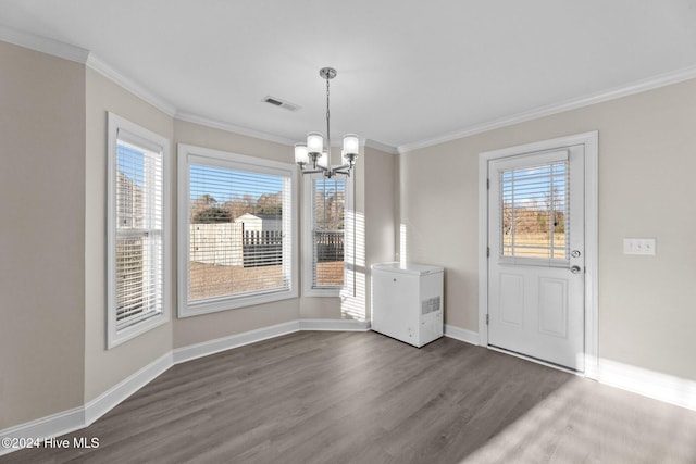 unfurnished dining area featuring dark hardwood / wood-style floors, ornamental molding, and a chandelier