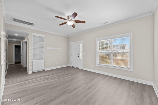 empty room with ceiling fan, crown molding, and light hardwood / wood-style flooring