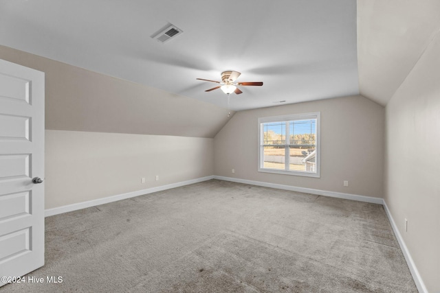 additional living space featuring ceiling fan, light carpet, and vaulted ceiling