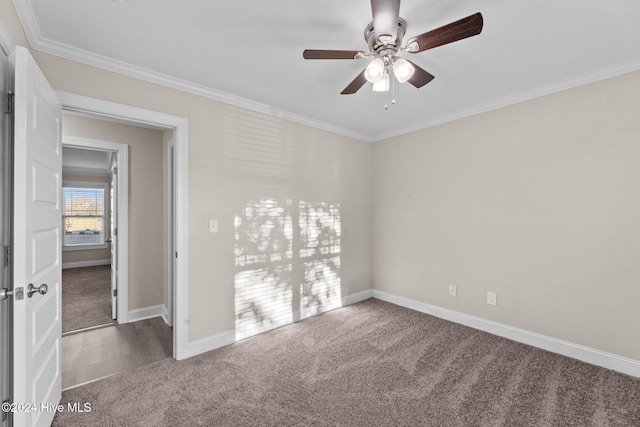 carpeted spare room with ceiling fan and crown molding