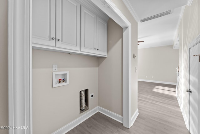 laundry room with hookup for an electric dryer, washer hookup, cabinets, and light hardwood / wood-style flooring