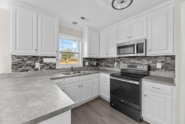 kitchen with hardwood / wood-style floors, white cabinets, sink, decorative light fixtures, and stainless steel appliances