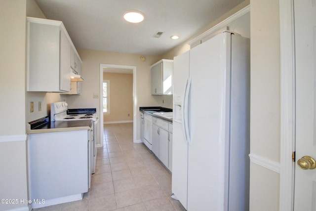 kitchen featuring light tile patterned floors, white cabinets, and white appliances