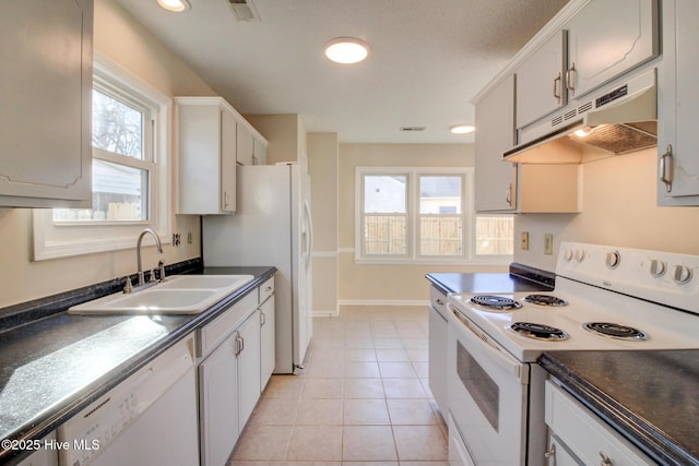 kitchen featuring light tile patterned floors, sink, white appliances, and white cabinetry