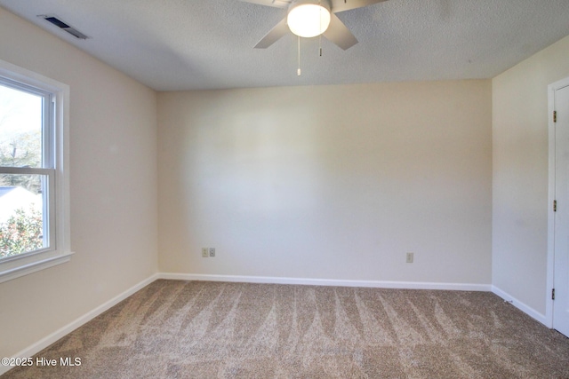 carpeted spare room with ceiling fan and a textured ceiling