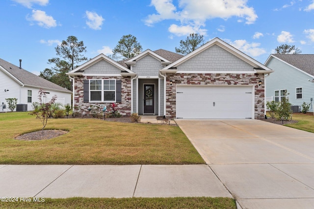 craftsman-style home featuring a garage, central air condition unit, and a front lawn