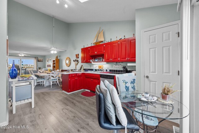 kitchen with a high ceiling, light hardwood / wood-style flooring, ceiling fan, and sink