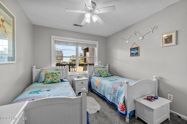 bedroom with ceiling fan and dark carpet