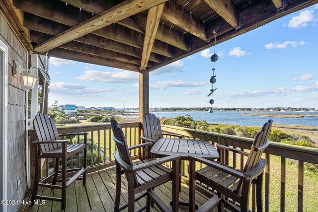 deck with a water view and a shed