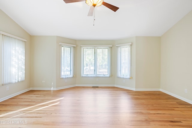 spare room with ceiling fan, light hardwood / wood-style floors, and vaulted ceiling