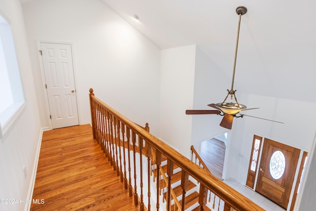 corridor with light hardwood / wood-style floors and vaulted ceiling