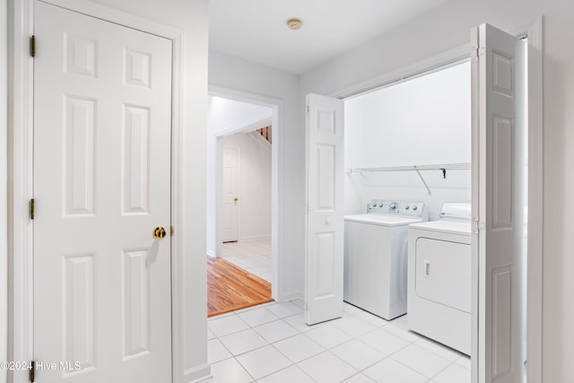 clothes washing area with separate washer and dryer and light hardwood / wood-style floors