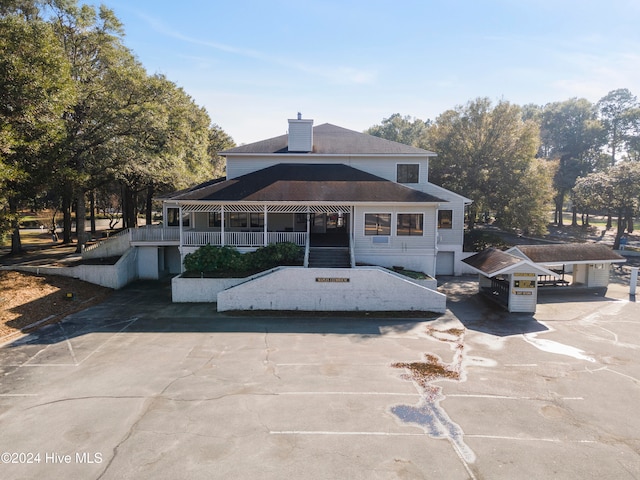 rear view of house featuring covered porch and a carport