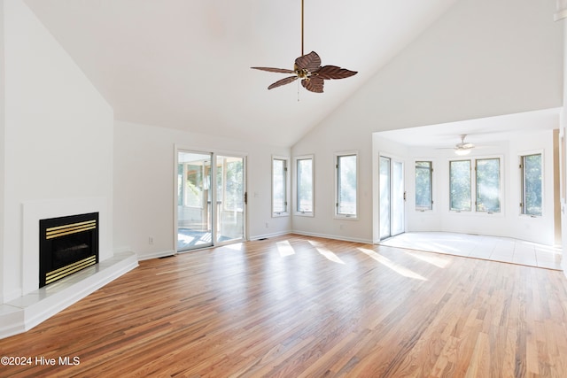 unfurnished living room with ceiling fan, light hardwood / wood-style flooring, and high vaulted ceiling