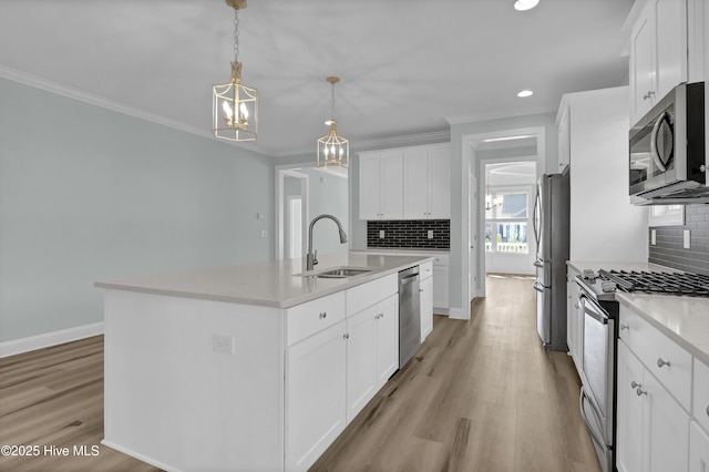 kitchen featuring light wood-type flooring, appliances with stainless steel finishes, ornamental molding, and white cabinets