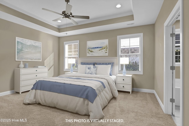 bedroom with multiple windows, a raised ceiling, and baseboards