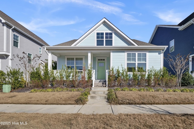 bungalow-style home featuring roof with shingles and a porch